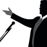 A vector silhouette illustration of a young man speaking into a microphone wearing a suit.